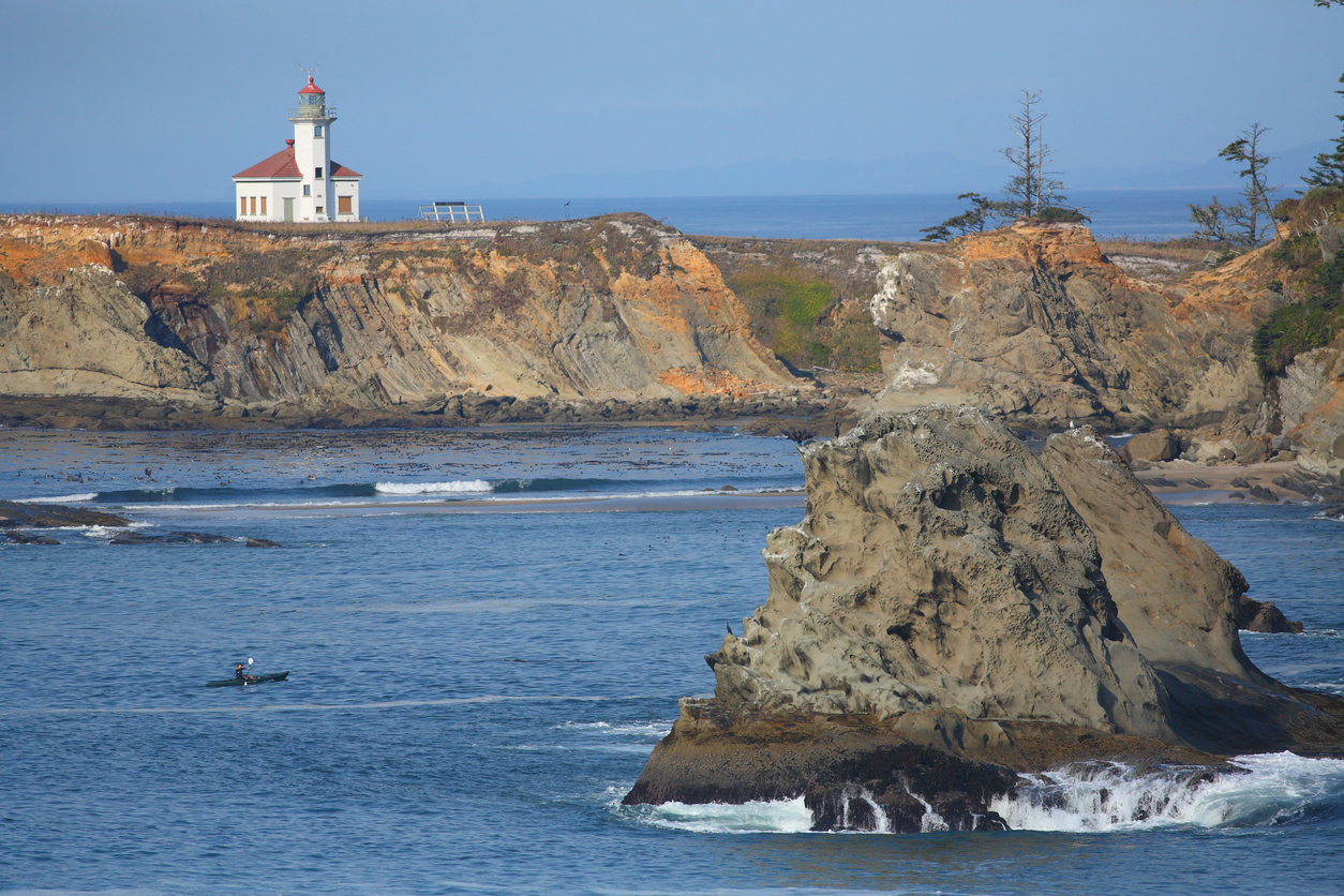 Cape Arago Lighthouse with kayaker and sea stack, Coos Bay Oregon